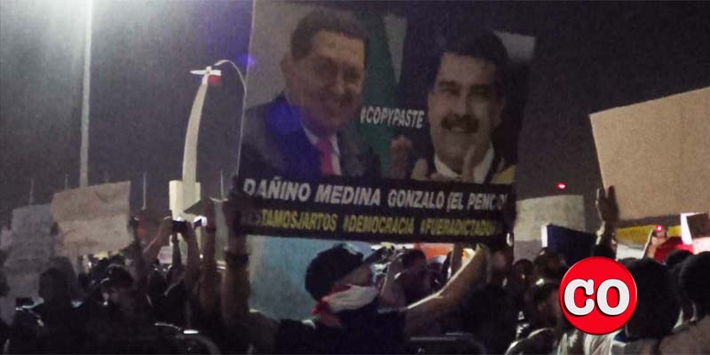 Un manifestante en la Plaza de la Bandera exhibe una pancarta contra Chávez y Maduro
