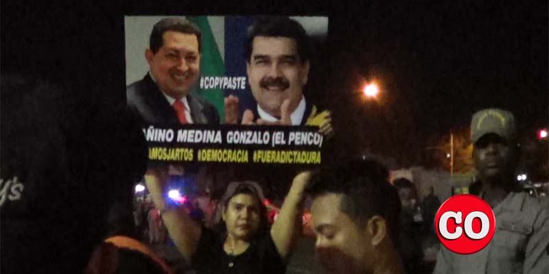 Una manifestante en la Plaza de la Bandera exhibe una pancarta cintra Chávez y Maduro