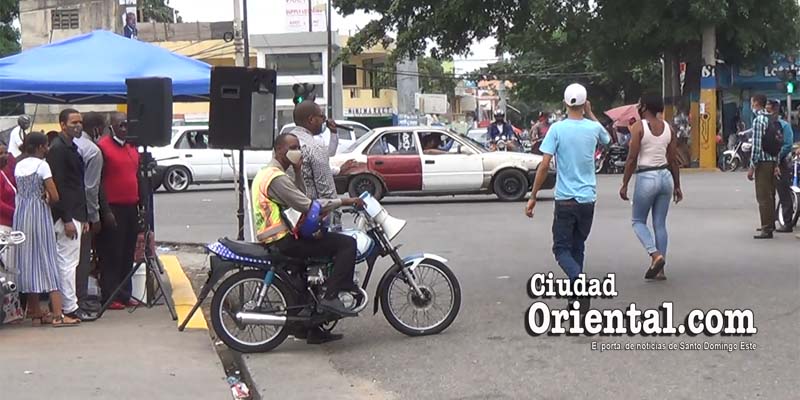 Peatones obligados a caminar en medio de la avenida Zrz. San Vicente de Paúl porque los evangélicos ocupan las aceras frente a la Bomba de Los Mina