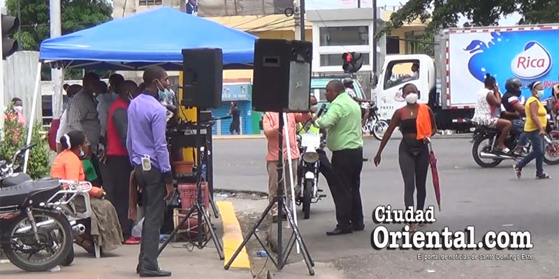 Una mujer s se ve obligado a caminar en medio de la calle porque los evangélicos ocupan las aceras en La Bomba de Los Mina